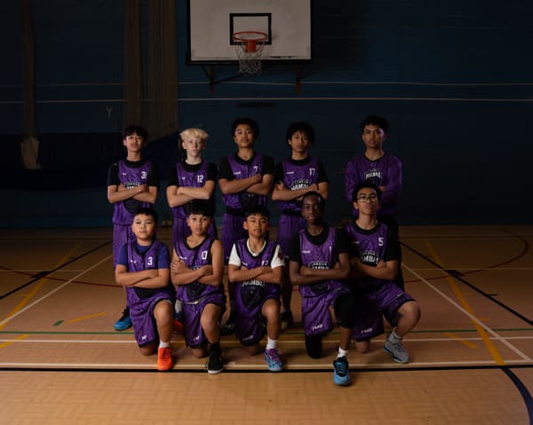 The U14 squad posing in purple kit under the basket